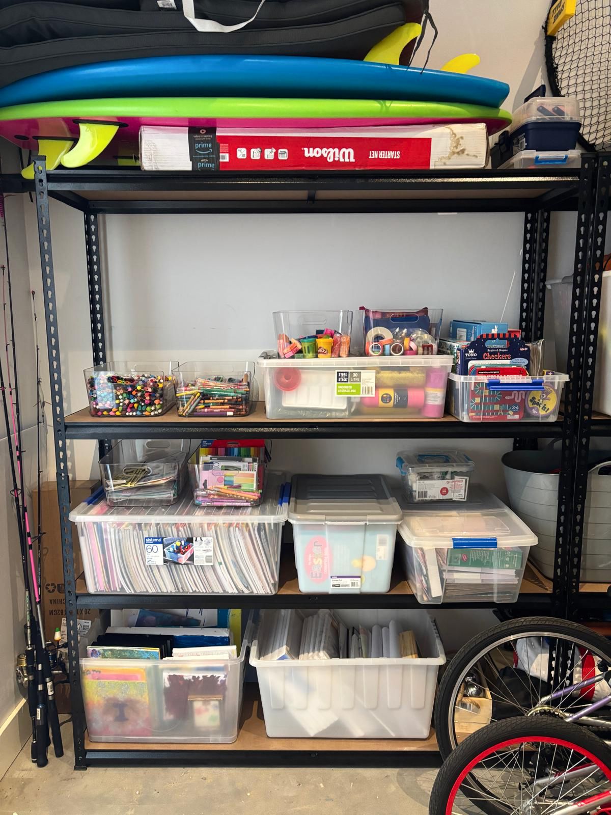 Garage shelves after organising, with supplies sorted into clear containers